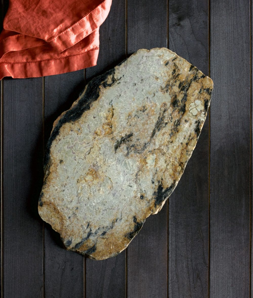 metamorphic stone charcuterie boards with white, black and yellow colors with red napkin on top of a wooden background