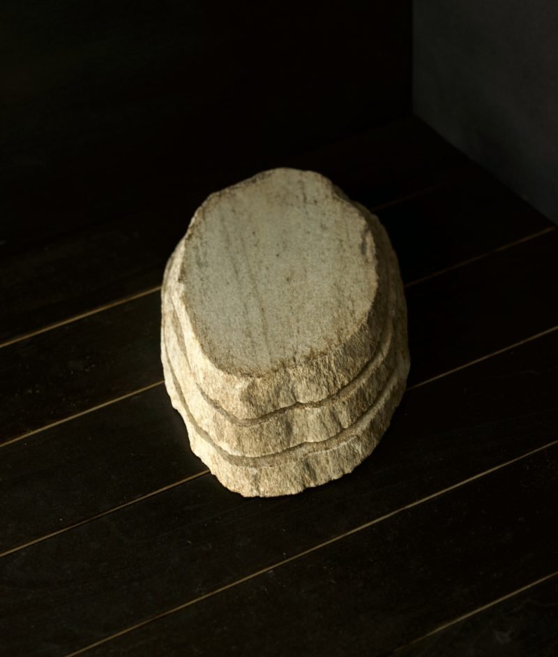 metamorphic stone trivet with gray, white and yellow colors on top of a wooden background