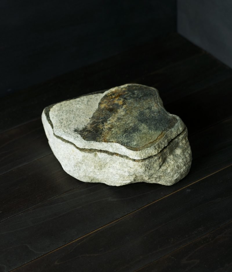metamorphic stone bowls with yellow, white and green colors on top of a wooden background