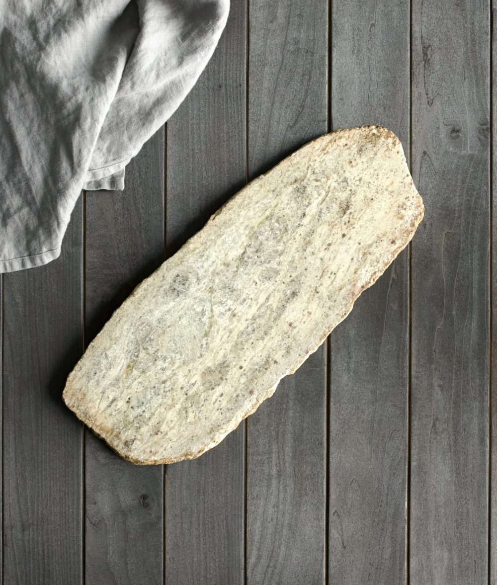 metamorphic stone charcuterie boards with white and yellow colors with white napkin on top of a wooden background
