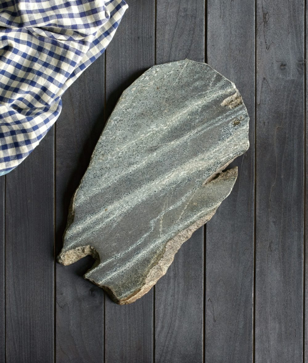 metamorphic stone charcuterie boards with gray, green and yellow colors with black and white napkin on top of a wooden background