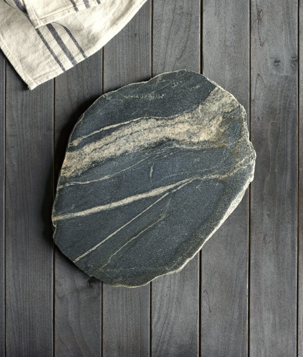 metamorphic stone charcuterie boards with gray and yellow colors with white napkin on top of a wooden background
