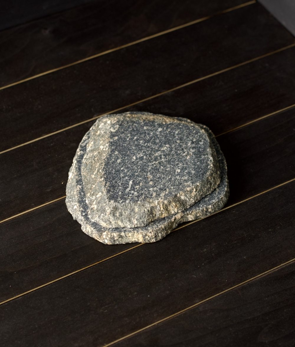 metamorphic stone coaster set with gray and yellow colors on top of a wooden background