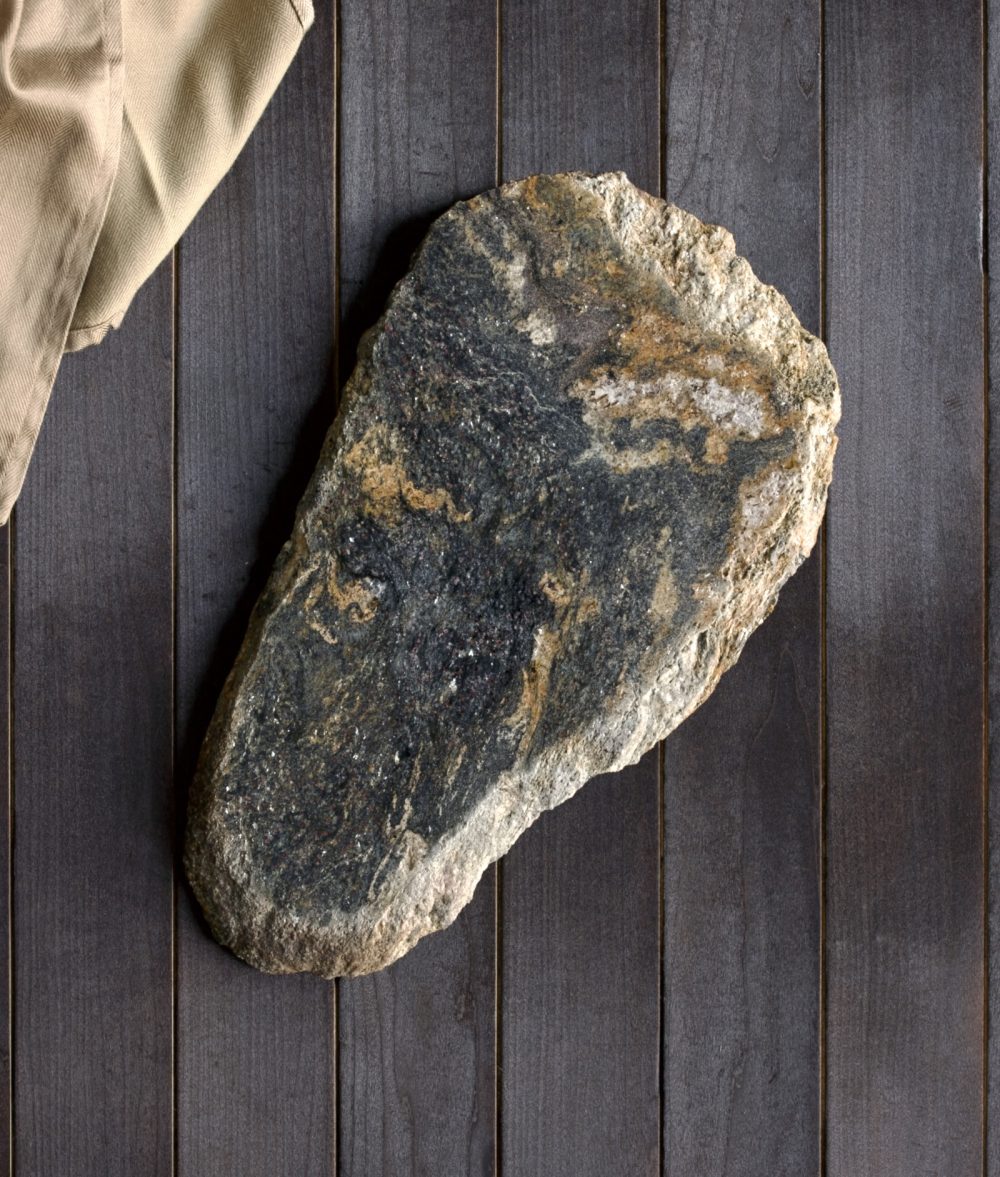 metamorphic stone charcuterie boards with gray, black and yellow colors with yellow napkin on top of a wooden background