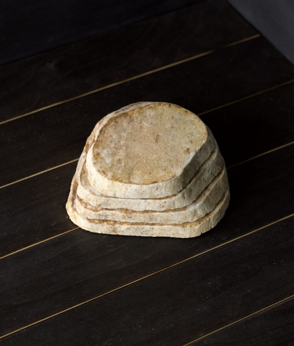 metamorphic stone coaster set with yellow and white colors on top of a wooden background