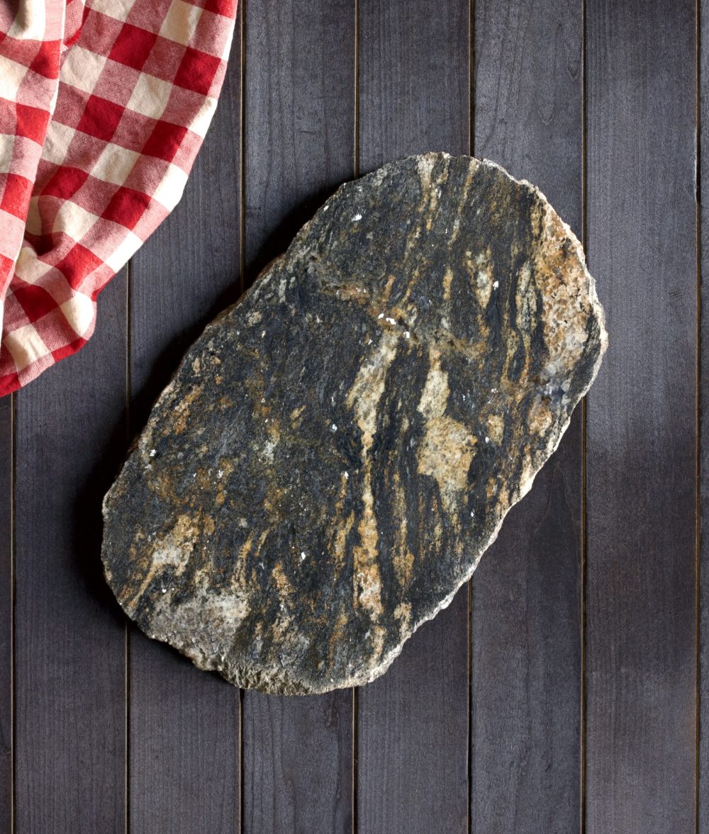 metamorphic stone charcuterie boards with gray, black and yellow colors with red and white napkin on top of a wooden background