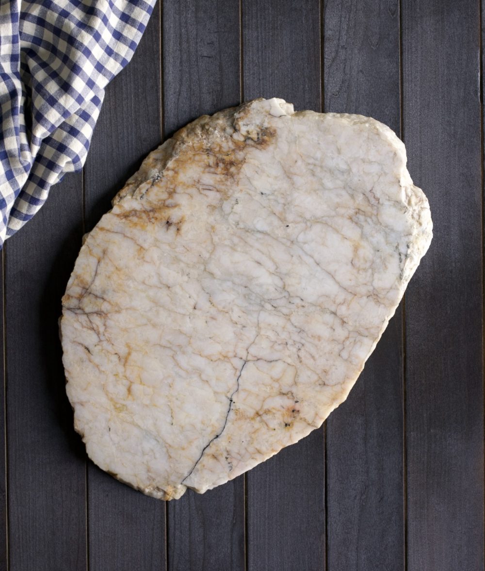 metamorphic stone charcuterie boards with gray, white and yellow colors with white and white napkin on top of a wooden background