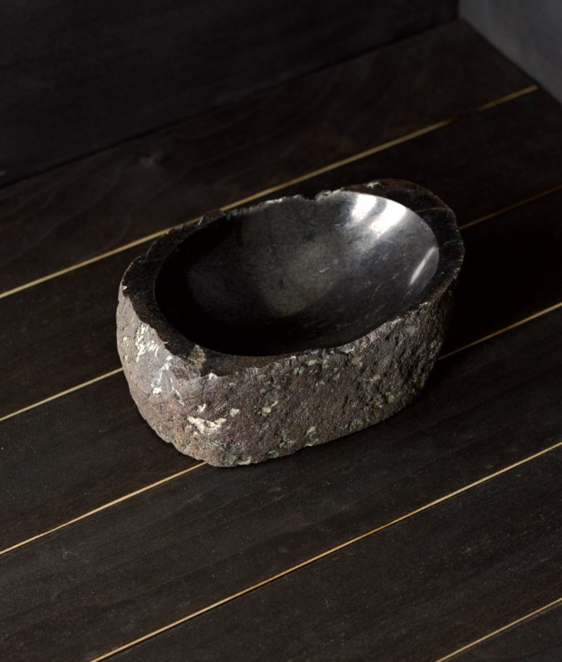 metamorphic stone bowl with gray, white and black colors on top of a wooden background