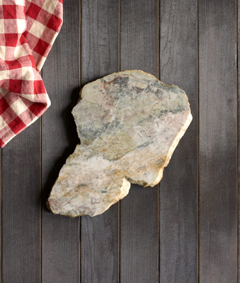 metamorphic stone charcuterie boards with gray and yellow colors with red and white napkin on top of a wooden background
