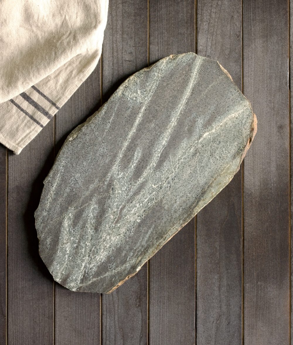 metamorphic stone charcuterie boards with gray and white colors with white napkin on top of a wooden background