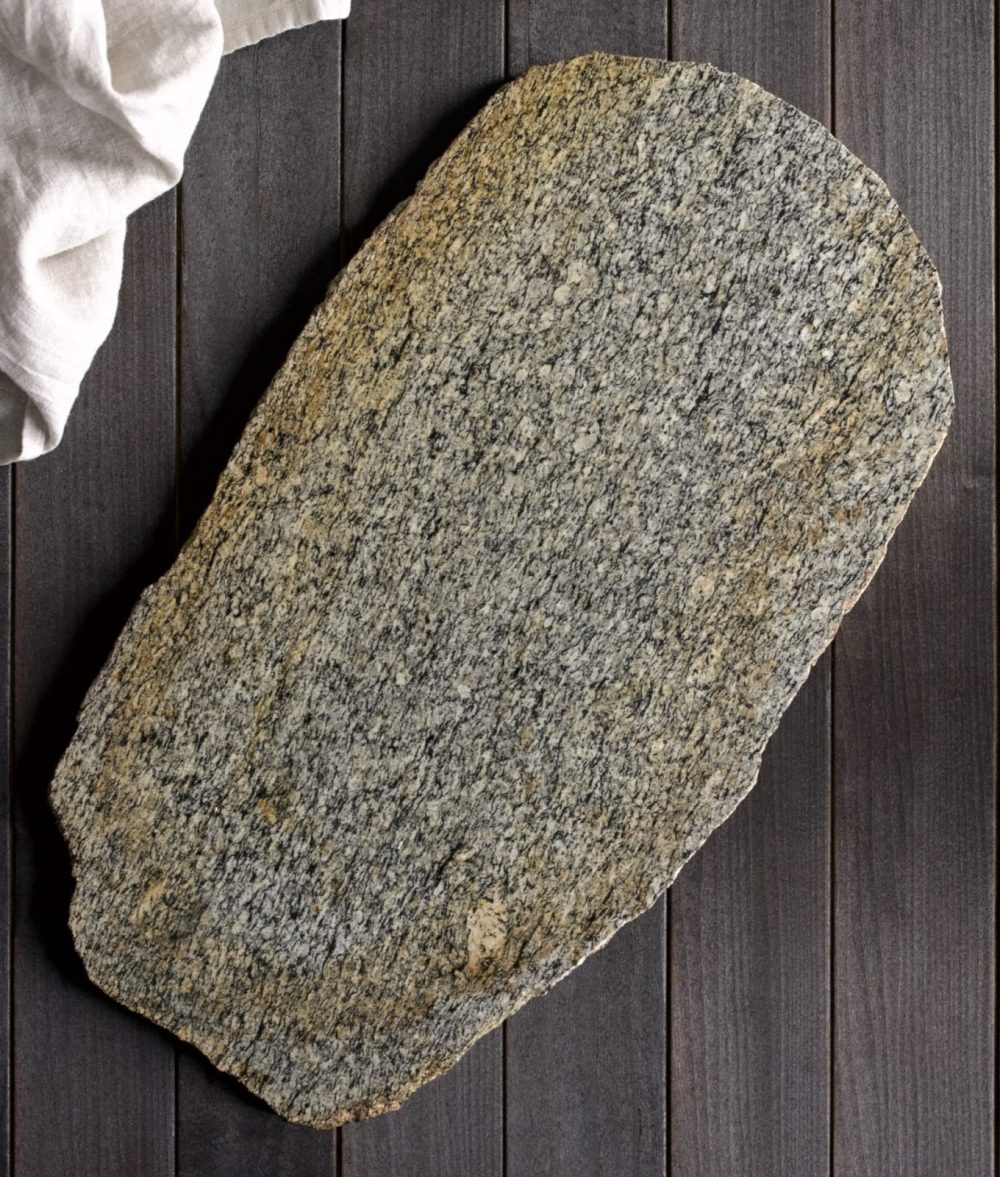 metamorphic stone charcuterie board with gray, yellow and white colors with white napkin on top of a wooden background