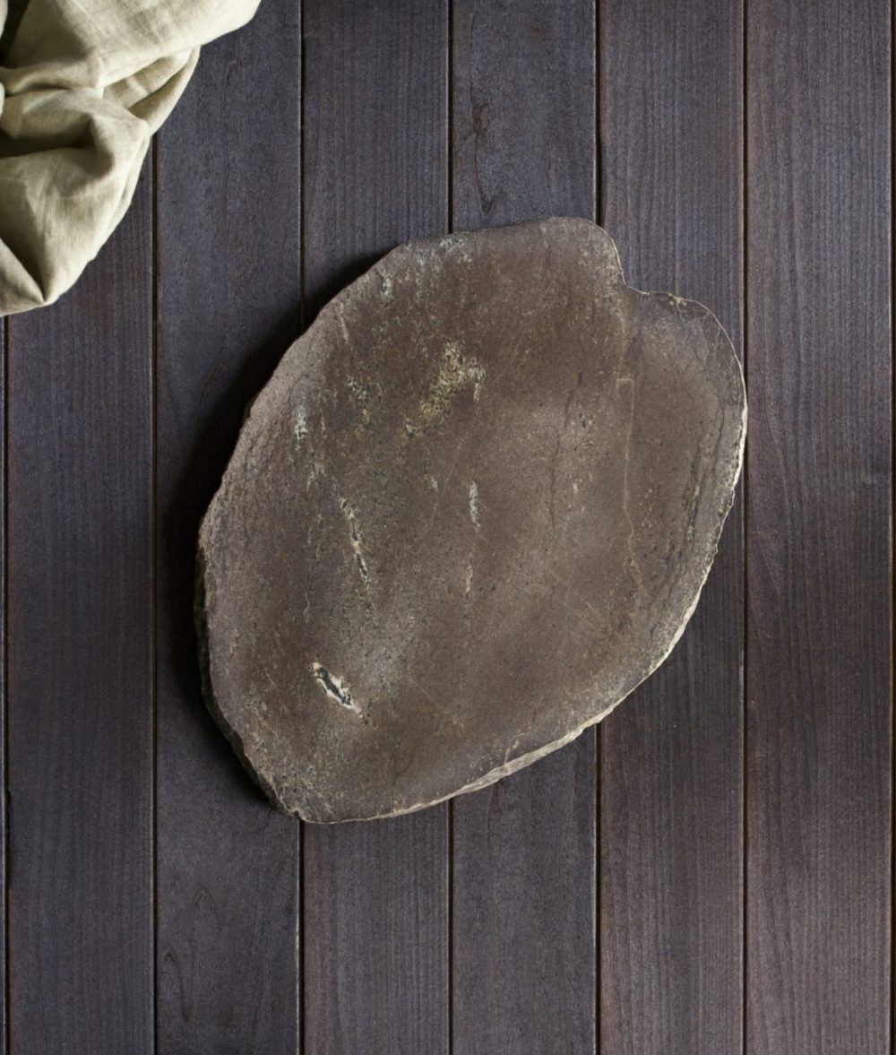 metamorphic stone charcuterie board with gray, brown and white colors with Dirty white napkin on top of a wooden background