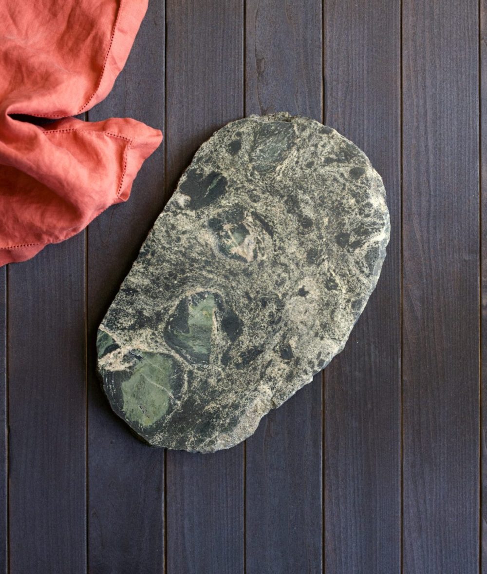 metamorphic stone charcuterie boards with gray, black and yellow colors with red napkin on top of a wooden background