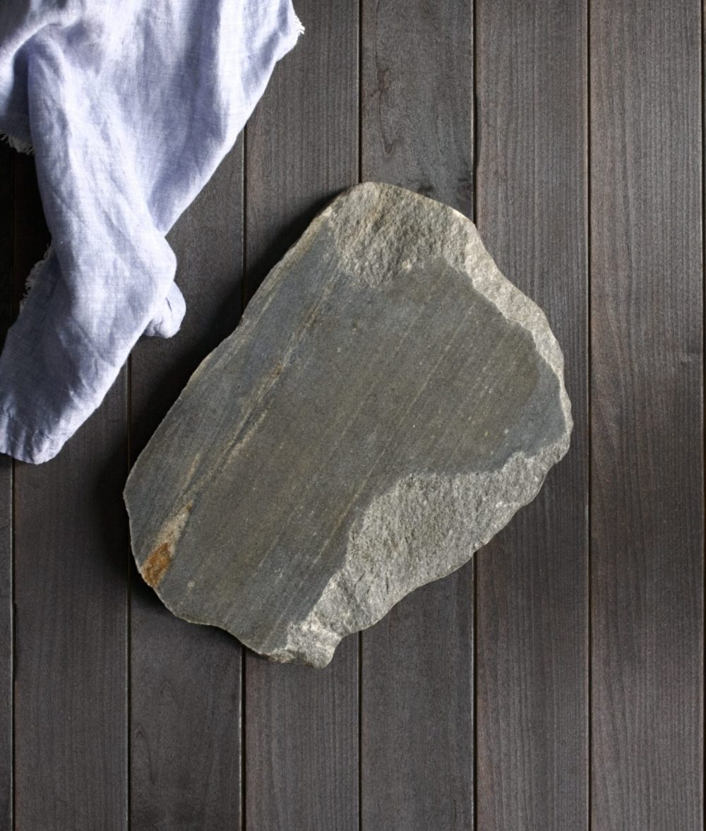 metamorphic stone charcuterie boards with gray and white colors with lavender napkin on top of a wooden background