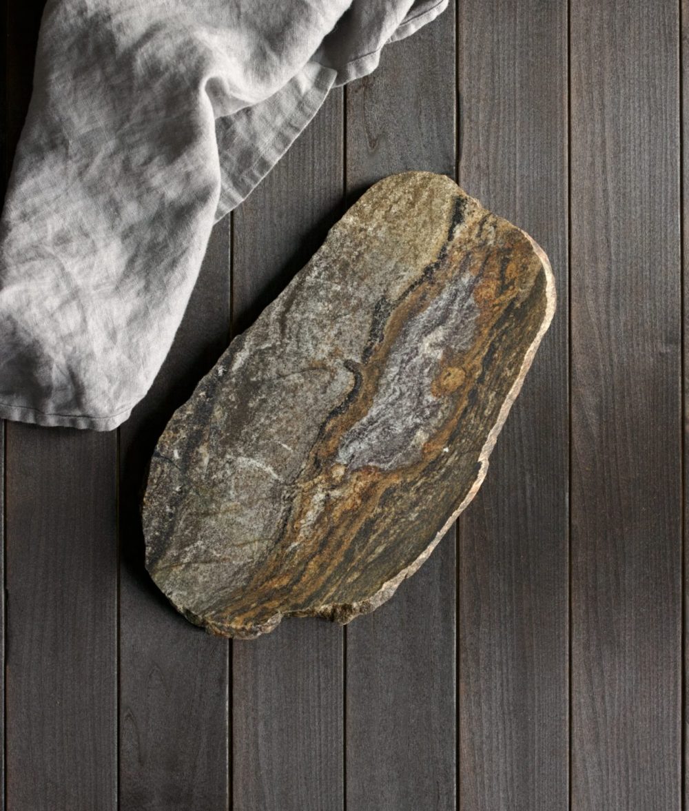 metamorphic stone charcuterie boards with gray and yellow colors with gray napkin on top of a wooden background