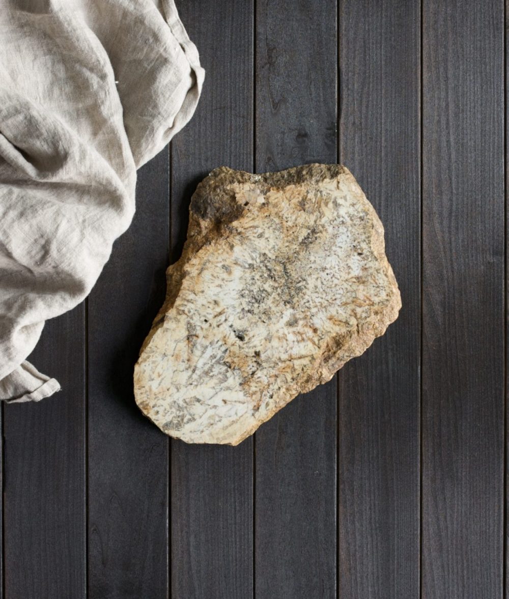 metamorphic stone charcuterie board with yellow and white colors with white napkin on top of a wooden background