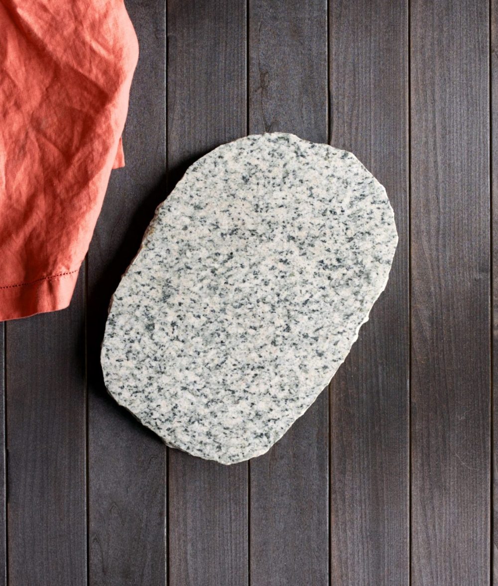 metamorphic stone charcuterie board with gray and white colors with red napkin on top of a wooden background